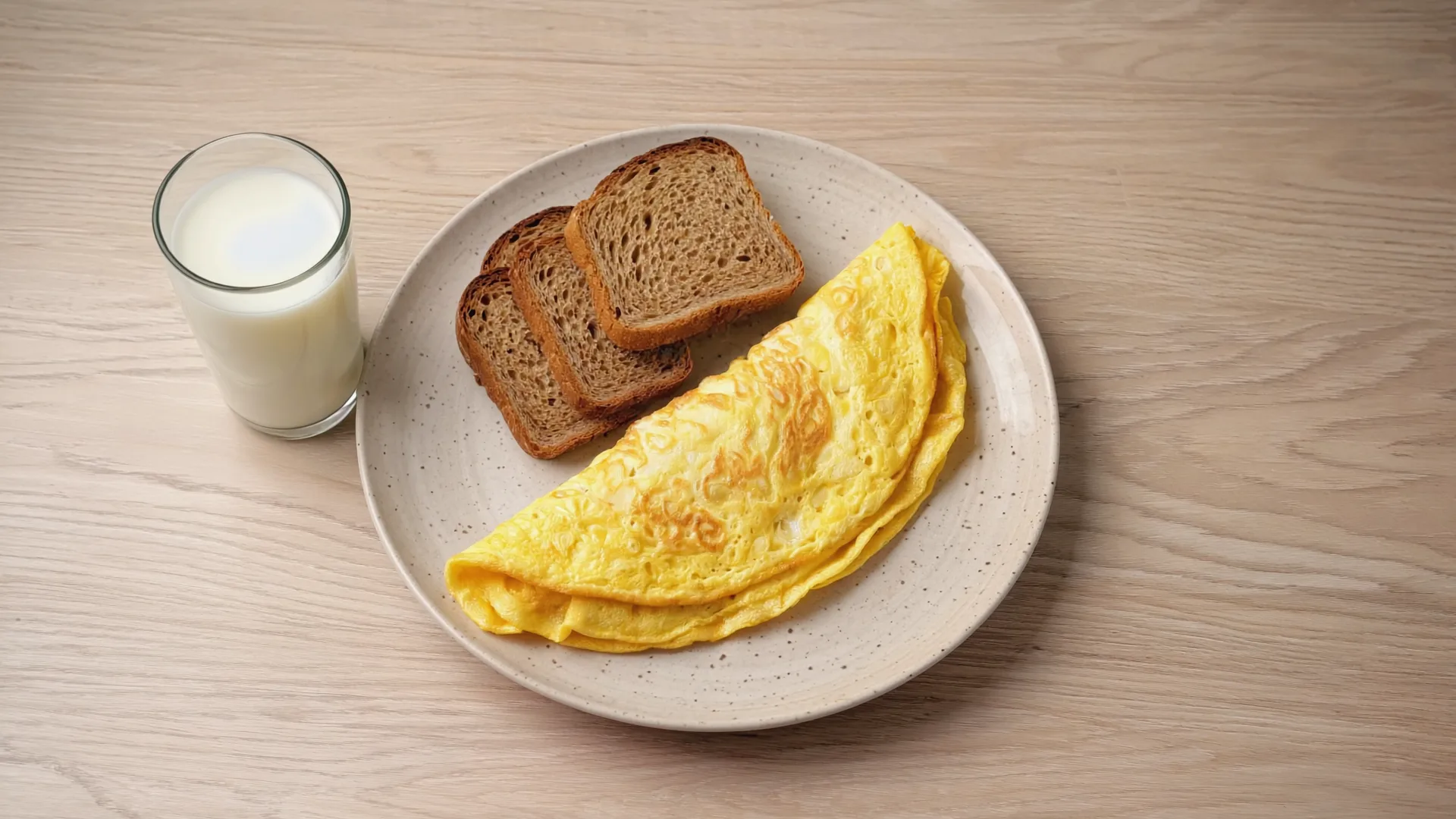 A bright Irish kitchen table in morning light with a two-egg omelette, brown bread and a glass of milk