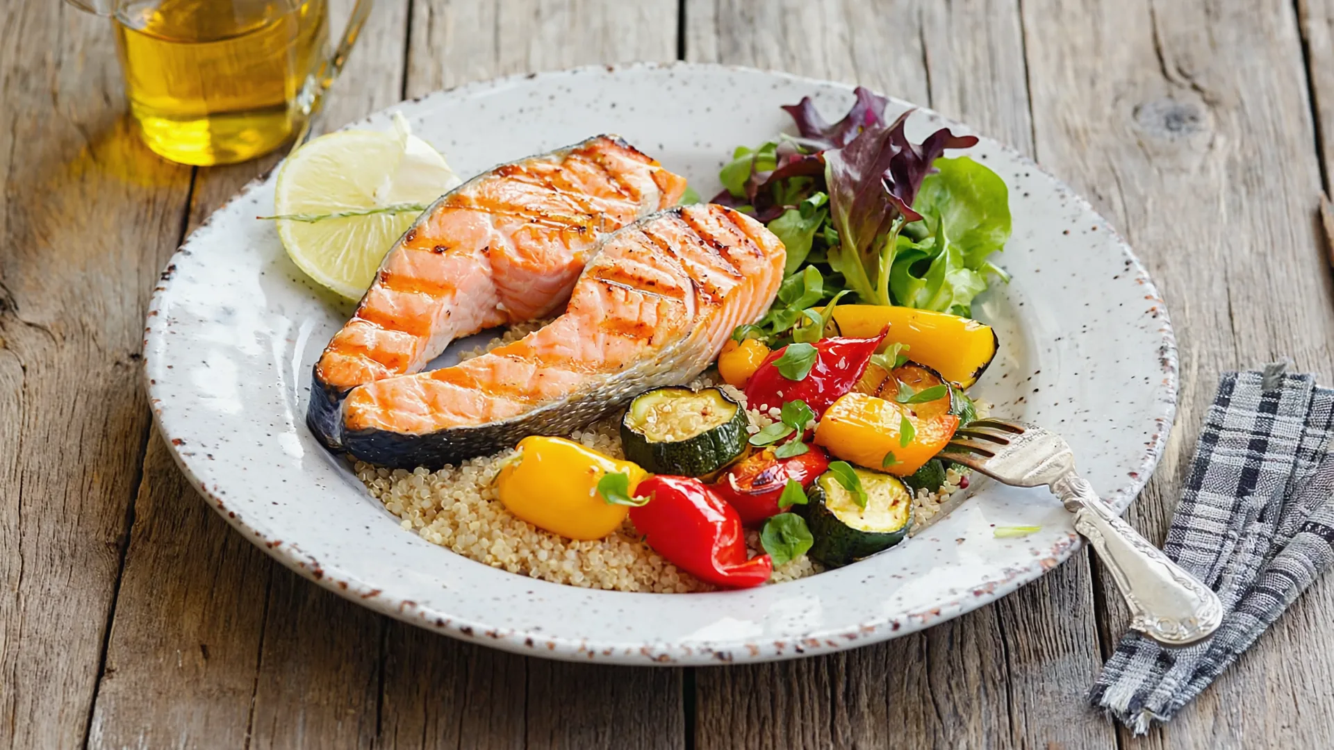 A balanced plate of food featuring grilled salmon, quinoa, roasted vegetables, and a salad, emphasizing protein-rich nutrition for muscle retention.