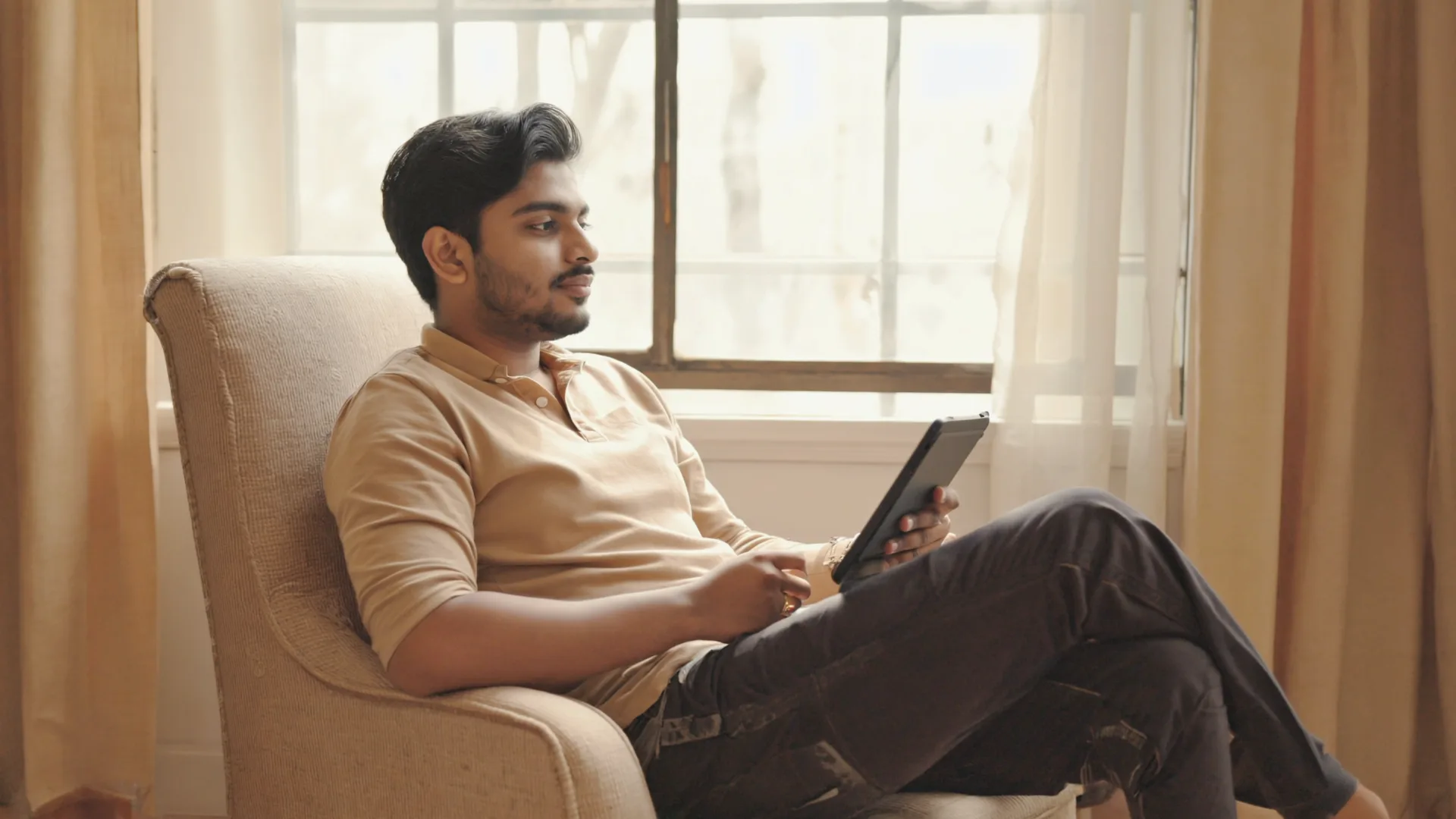 A person at home reading health and science news on a tablet by a sunlit window, calm and curious