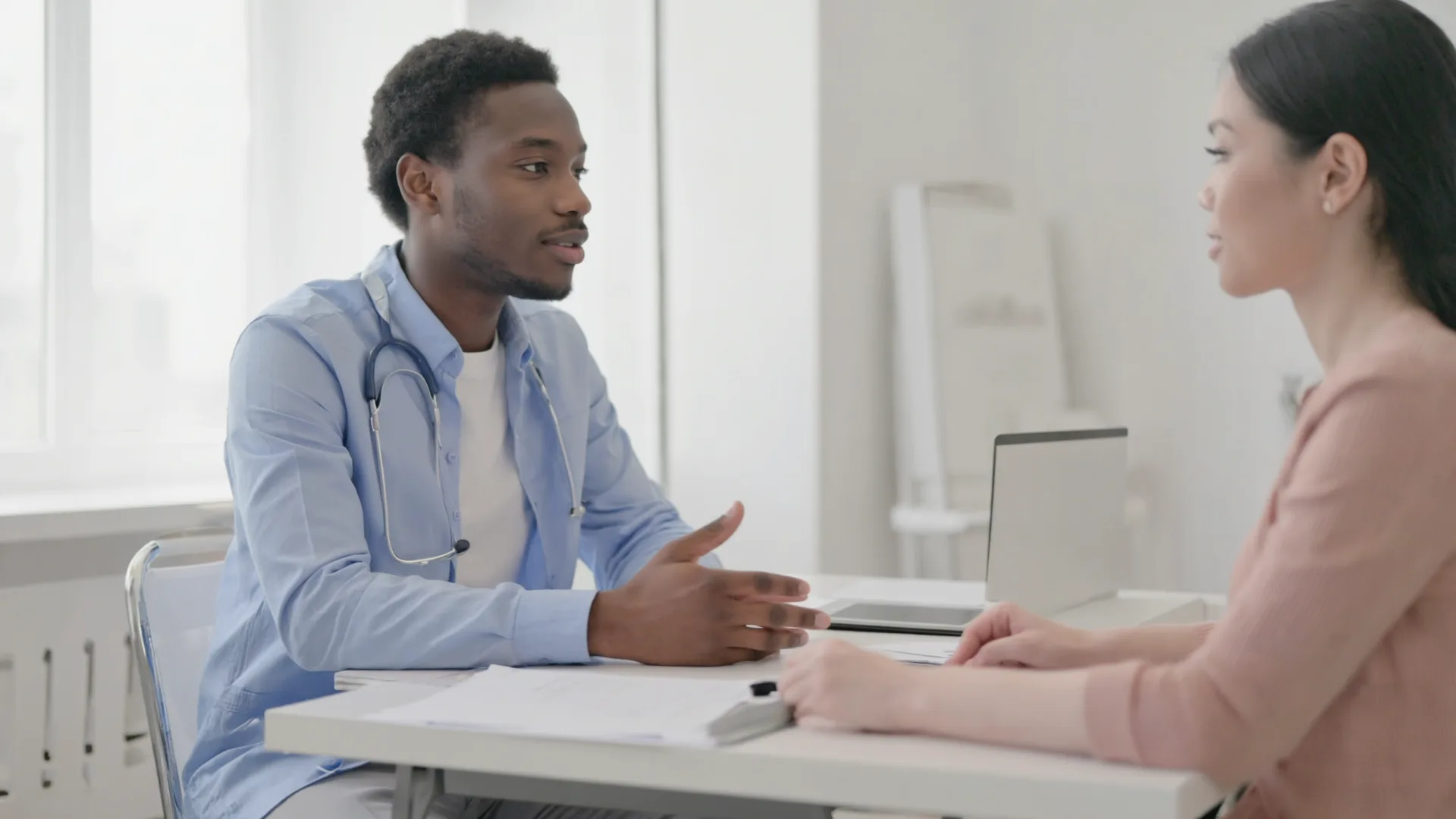 A doctor talking with a patient in a bright consultation room in Ireland