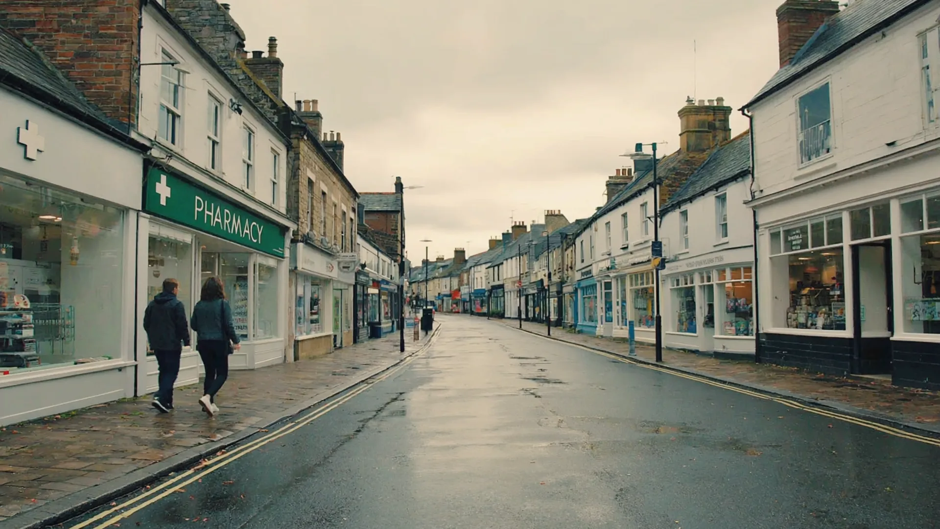 An Irish high street pharmacy A calm Irish town street on a soft overcast morning with a pharmacy shopfront and wet pavement